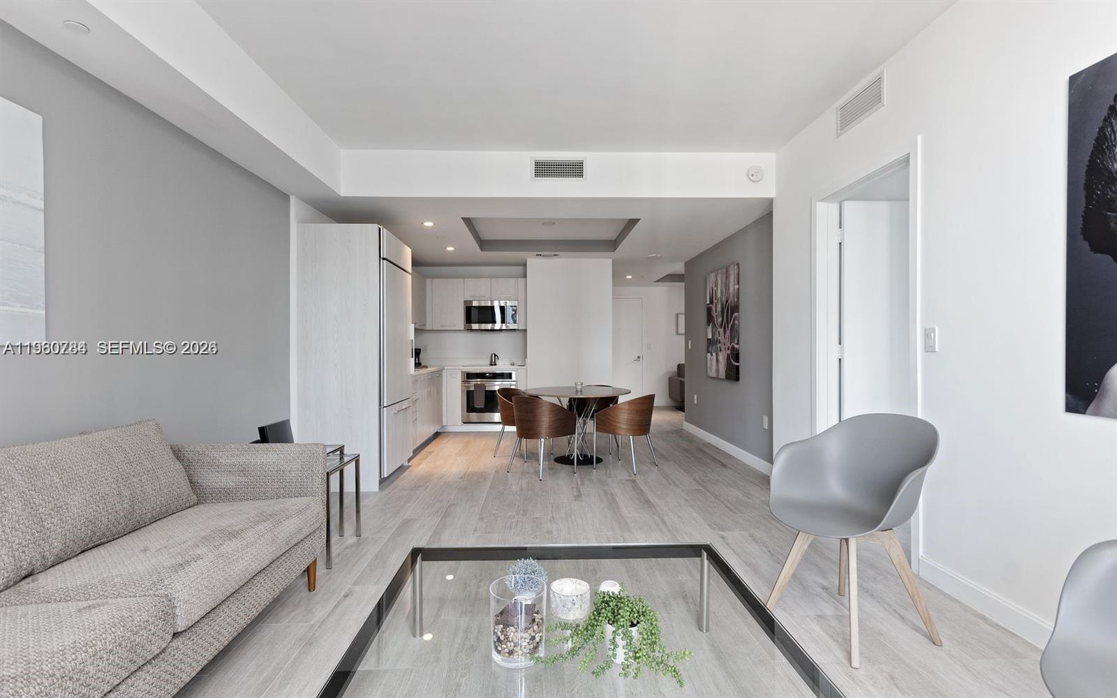 45 Southwest 9th Street, Unit 1805 Miami, FL 33130 - Photo 2 of 22 a living room with furniture and a large window