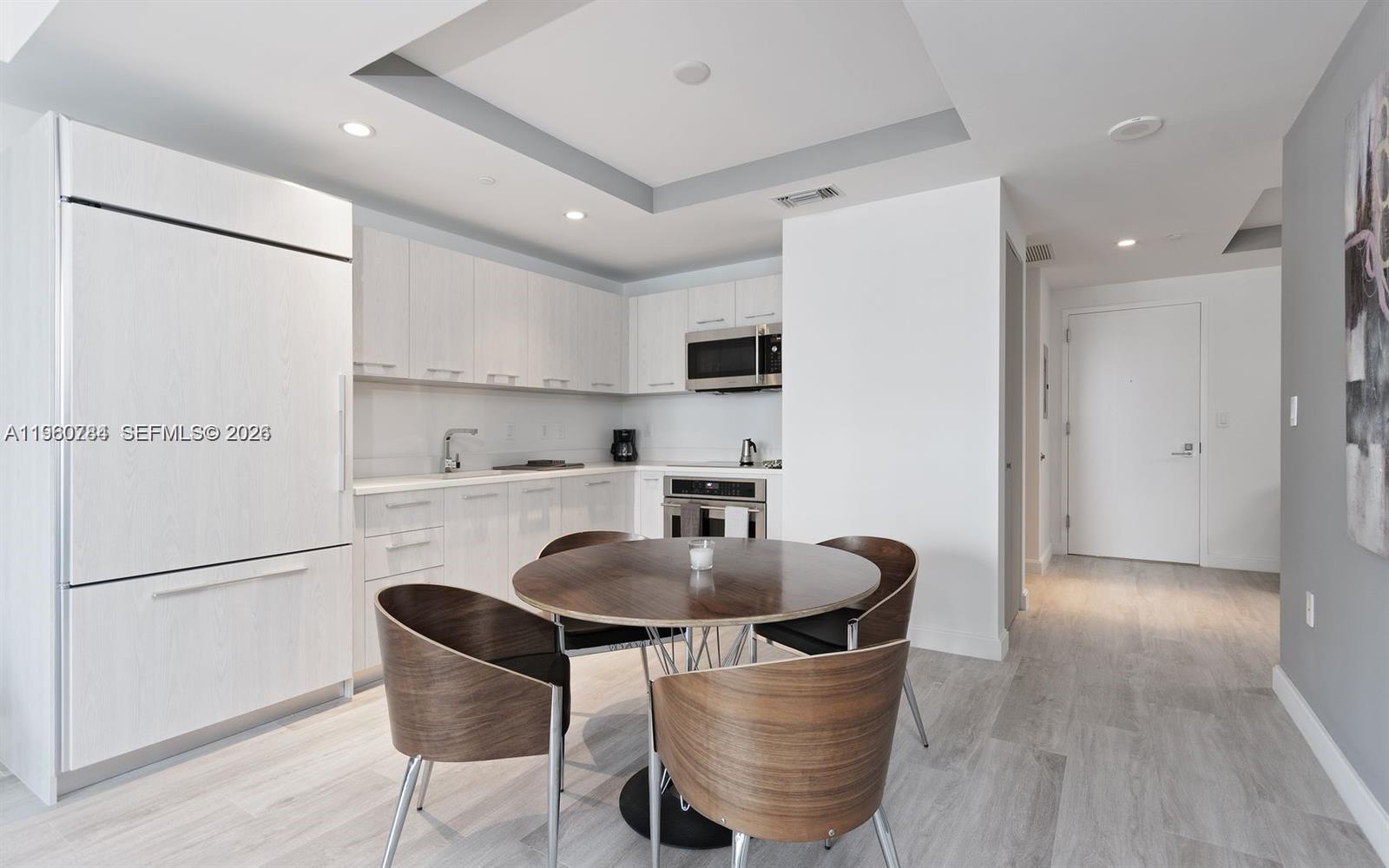 45 Southwest 9th Street, Unit 1805 Miami, FL 33130 - Photo 4 of 22 a kitchen with kitchen island a appliances dining table and chairs