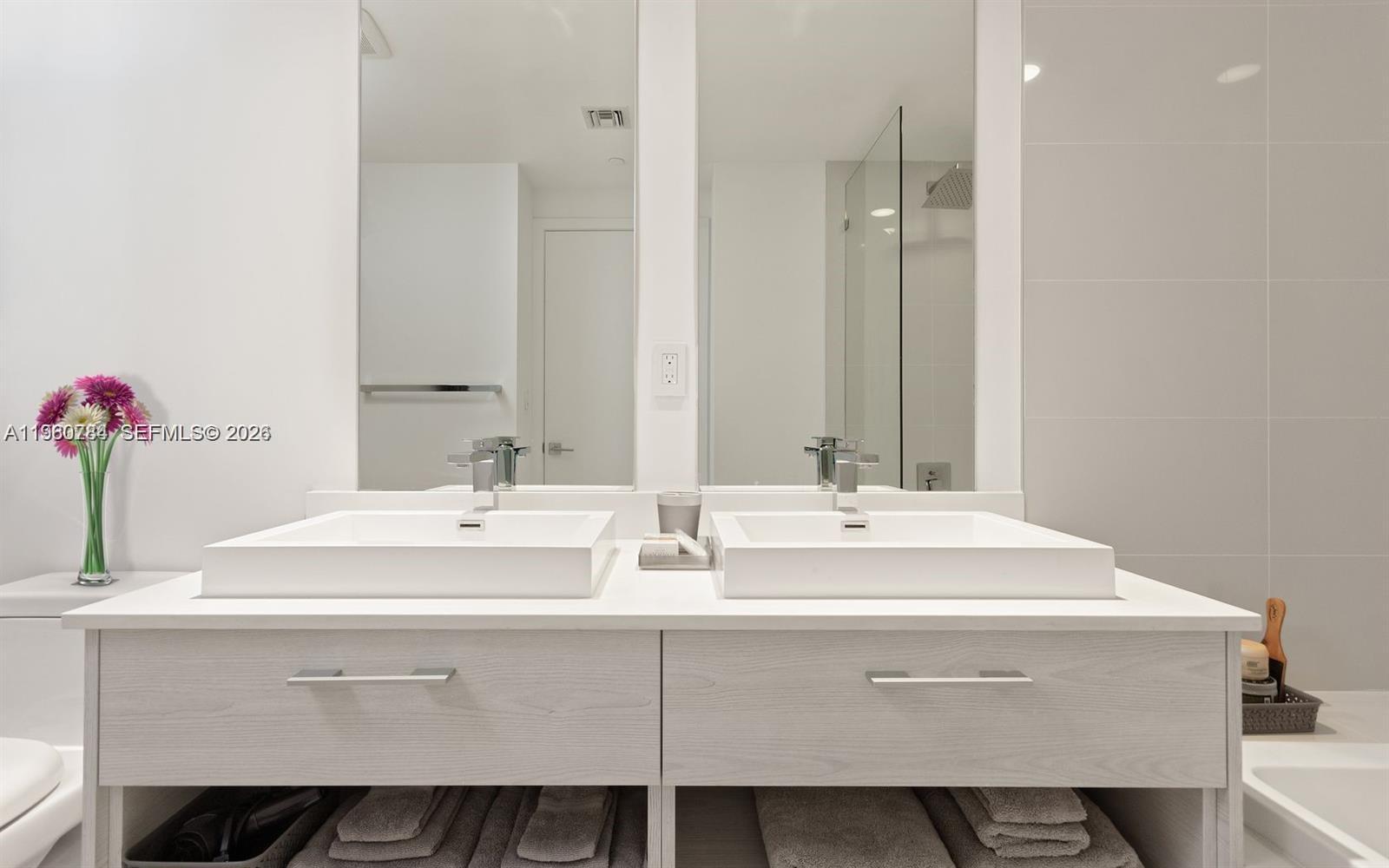 45 Southwest 9th Street, Unit 1805 Miami, FL 33130 - Photo 8 of 22 a bathroom with a sink and a mirror