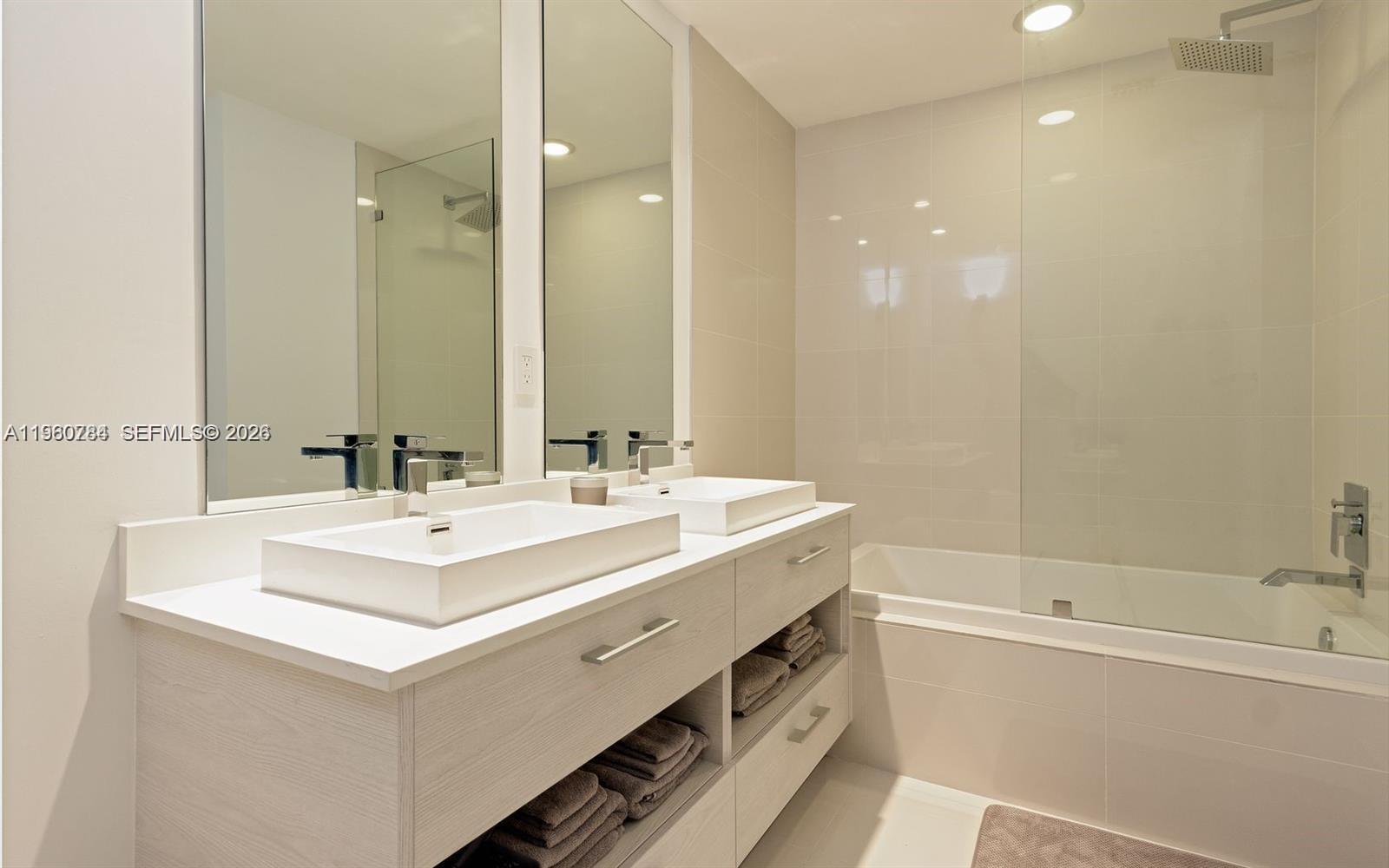 45 Southwest 9th Street, Unit 1805 Miami, FL 33130 - Photo 9 of 22 a bathroom with a sink a mirror and a bathtub