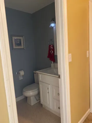 a white toilet sitting next to a bathroom sink and vanity