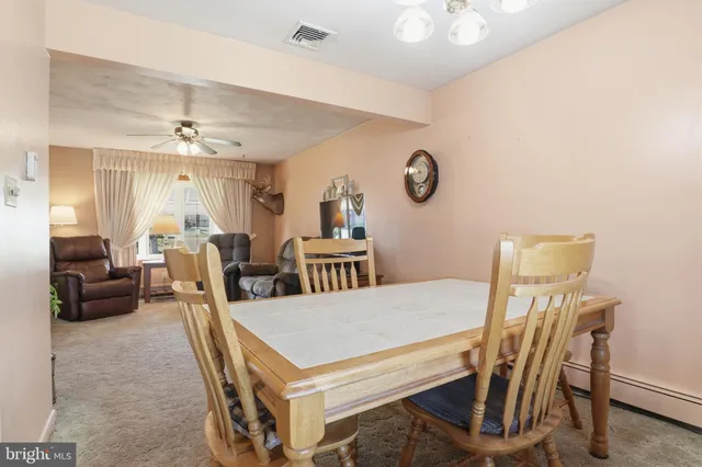a view of a dining room with furniture and a chandelier