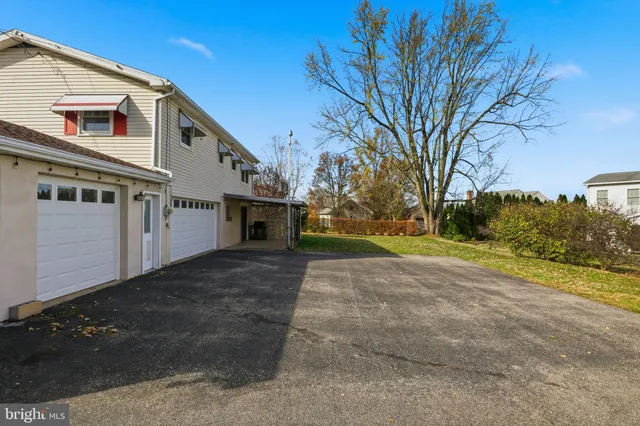 a view of a house with a big yard and large trees
