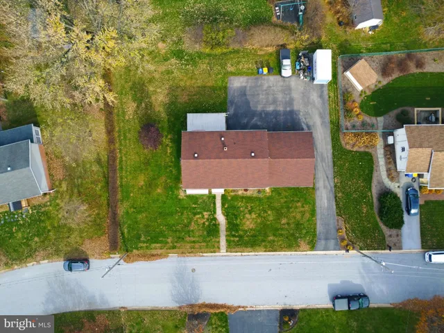 a view of a house with a big yard and large trees
