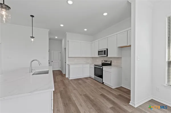 a kitchen with a refrigerator sink and cabinets