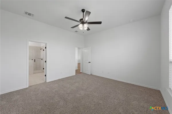 an empty room with a window and a ceiling fan