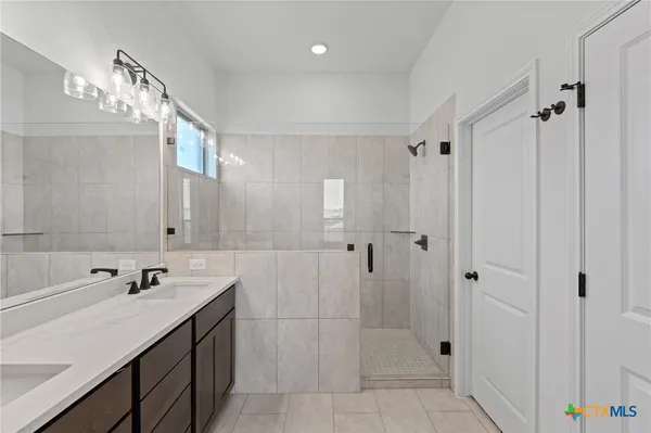 a spacious bathroom with a shower sink and mirror