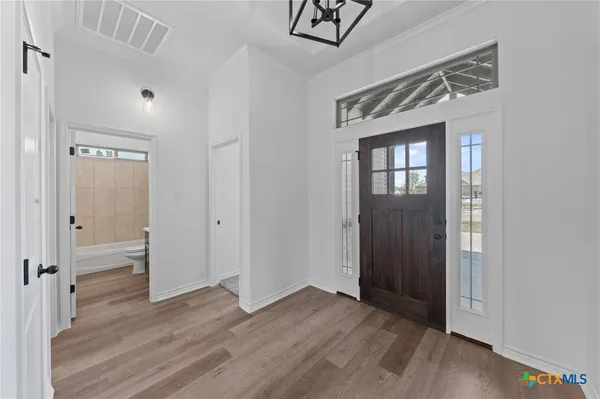 a view of a hallway with wooden floor and closet area