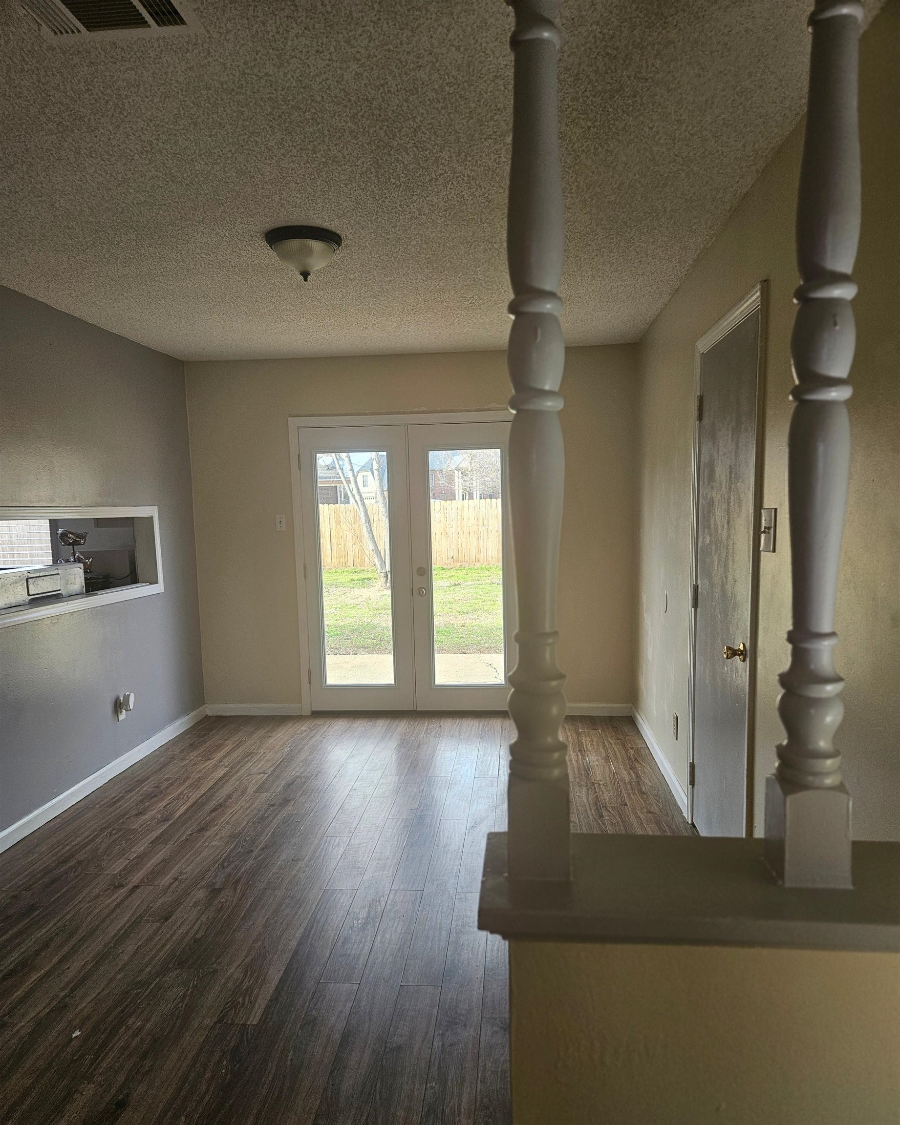 4262 Water Briar Road Millington, TN 38053 - Photo 5 of 21 Unfurnished living room featuring dark wood-style flooring, visible vents, baseboards, and french doors