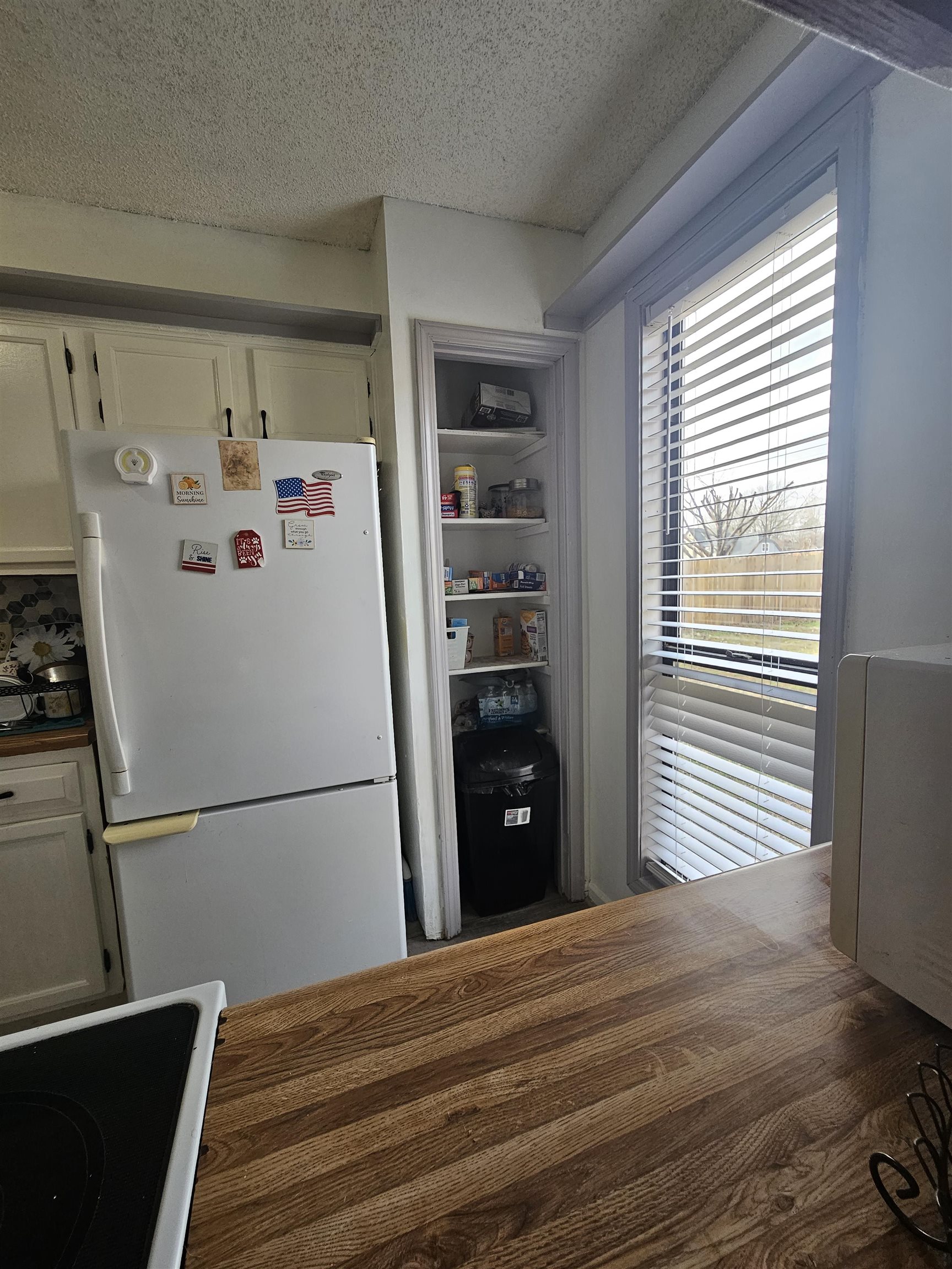 4262 Water Briar Road Millington, TN 38053 - Photo 7 of 21 Kitchen featuring freestanding refrigerator, white cabinetry, wooden counters, and a textured ceiling