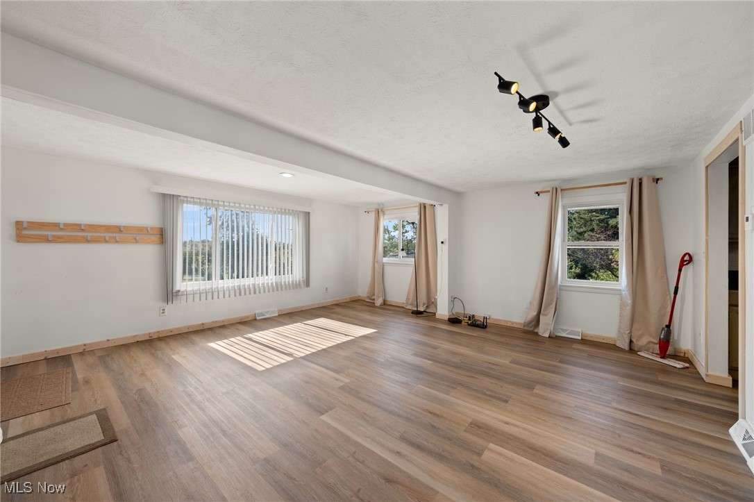 793 Chaffin Road Akron, OH 44306 - Photo 7 of 28 Empty room with a wealth of natural light and wood-type flooring