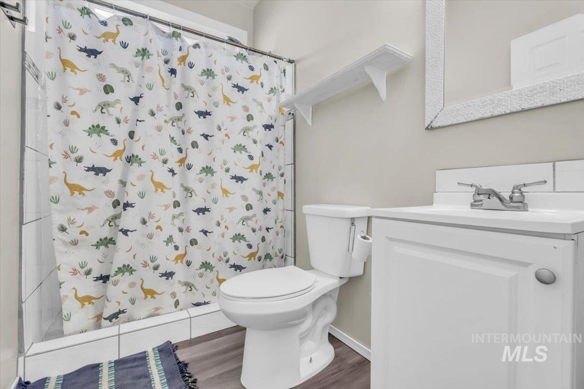15046 Burger Lane Caldwell, ID 83607 - Photo 13 of 31 Bathroom featuring a shower with curtain, vanity, and wood finished floors