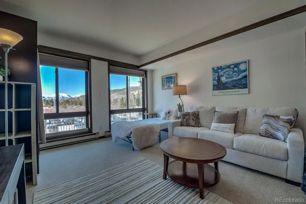 a living room with furniture and a floor to ceiling window