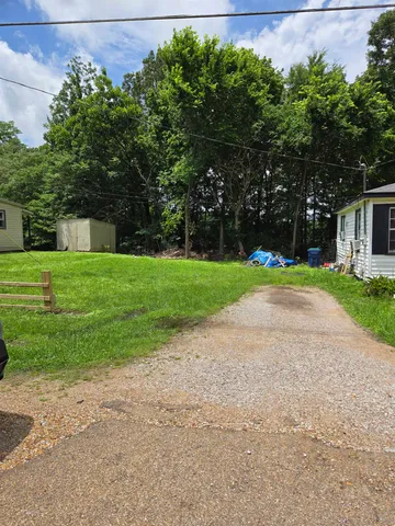 a view of a backyard with large trees