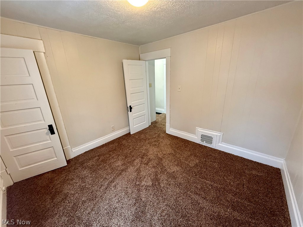 39 North Balch Street Akron, OH 44303 - Photo 16 of 19 Unfurnished bedroom featuring dark carpet and a textured ceiling