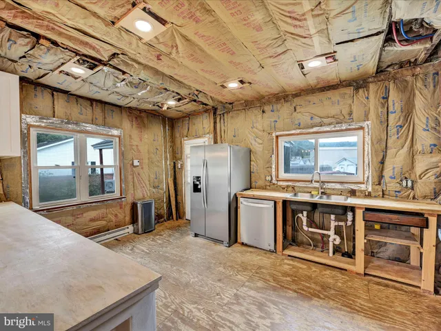 a large kitchen with stainless steel appliances granite countertop a sink and a refrigerator