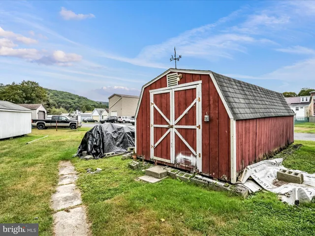 a view of a house with a big yard and large trees