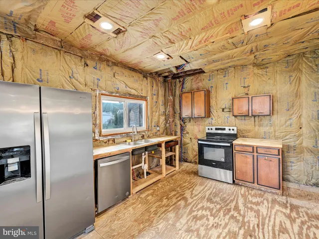 a kitchen with stainless steel appliances granite countertop a stove a refrigerator and a sink