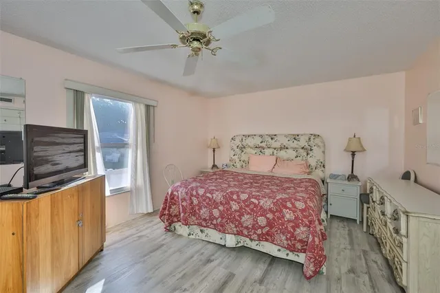 a bedroom with a bed a chandelier and dresser