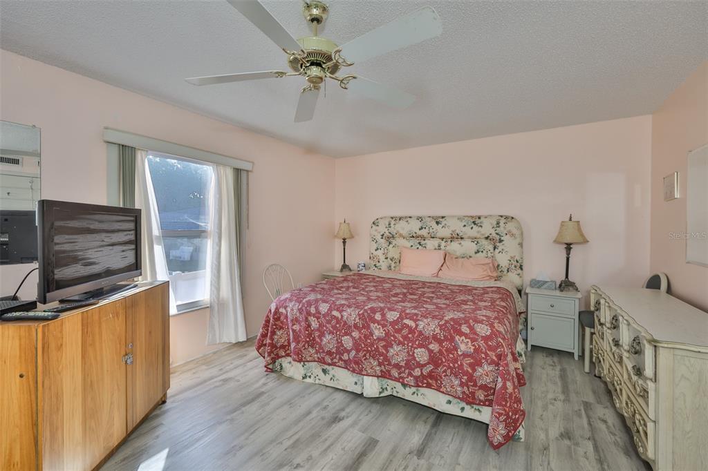 12760 Indian Rocks Road, Unit 413 Largo, FL 33774 - Photo 12 of 27 a bedroom with a bed a chandelier and dresser