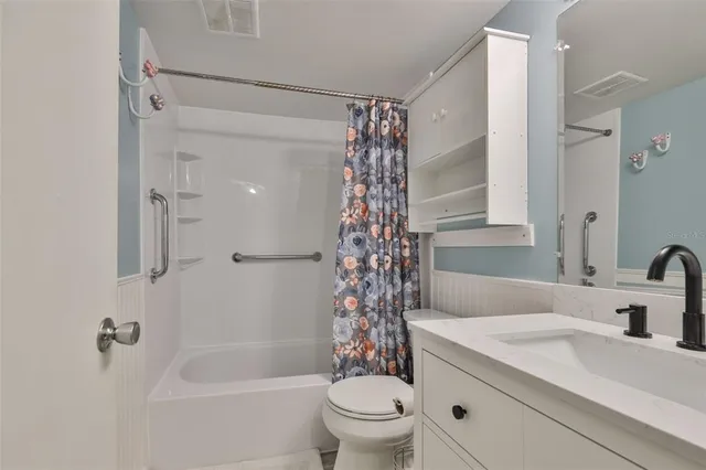a bathroom with a granite countertop sink a toilet and shower