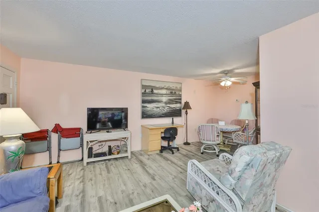 a living room with furniture a flat screen tv and a large window