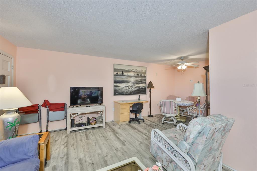 12760 Indian Rocks Road, Unit 413 Largo, FL 33774 - Photo 7 of 27 a living room with furniture a flat screen tv and a large window