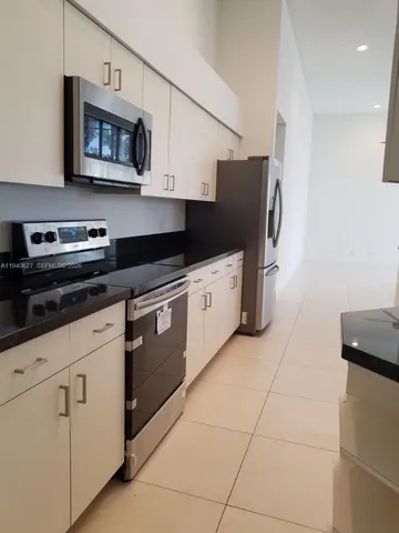 a kitchen with stainless steel appliances granite countertop a stove a microwave and a refrigerator