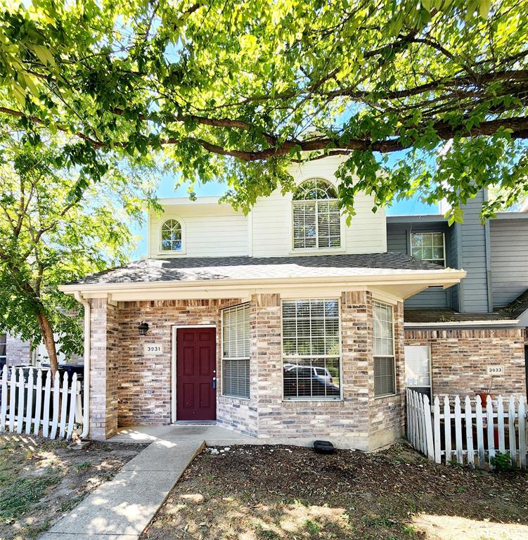 a front view of a house with a large tree