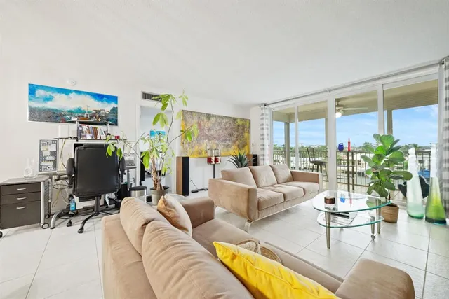 a living room with furniture a lamp a potted plant and a large window