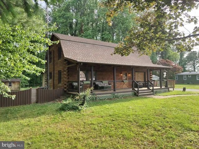 a backyard of a house with table and chairs and wooden fence