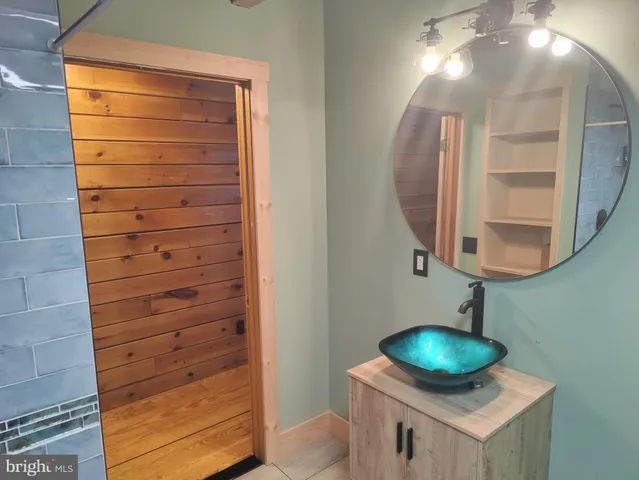 a view of a hallway and closet with wooden floor