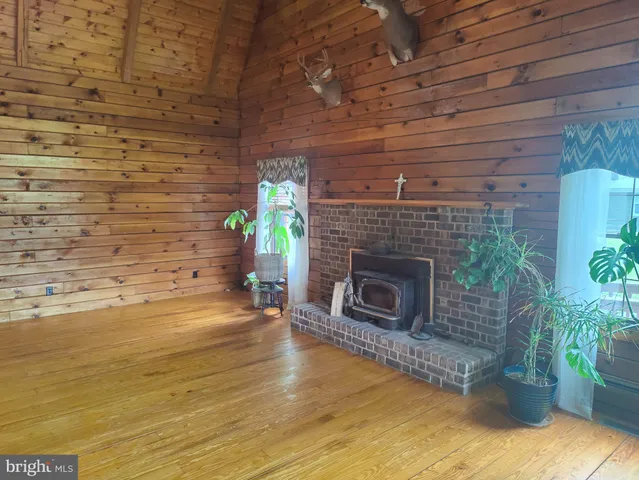a view of empty room with wooden floor and fireplace