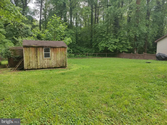 a view of a backyard with barn and large trees