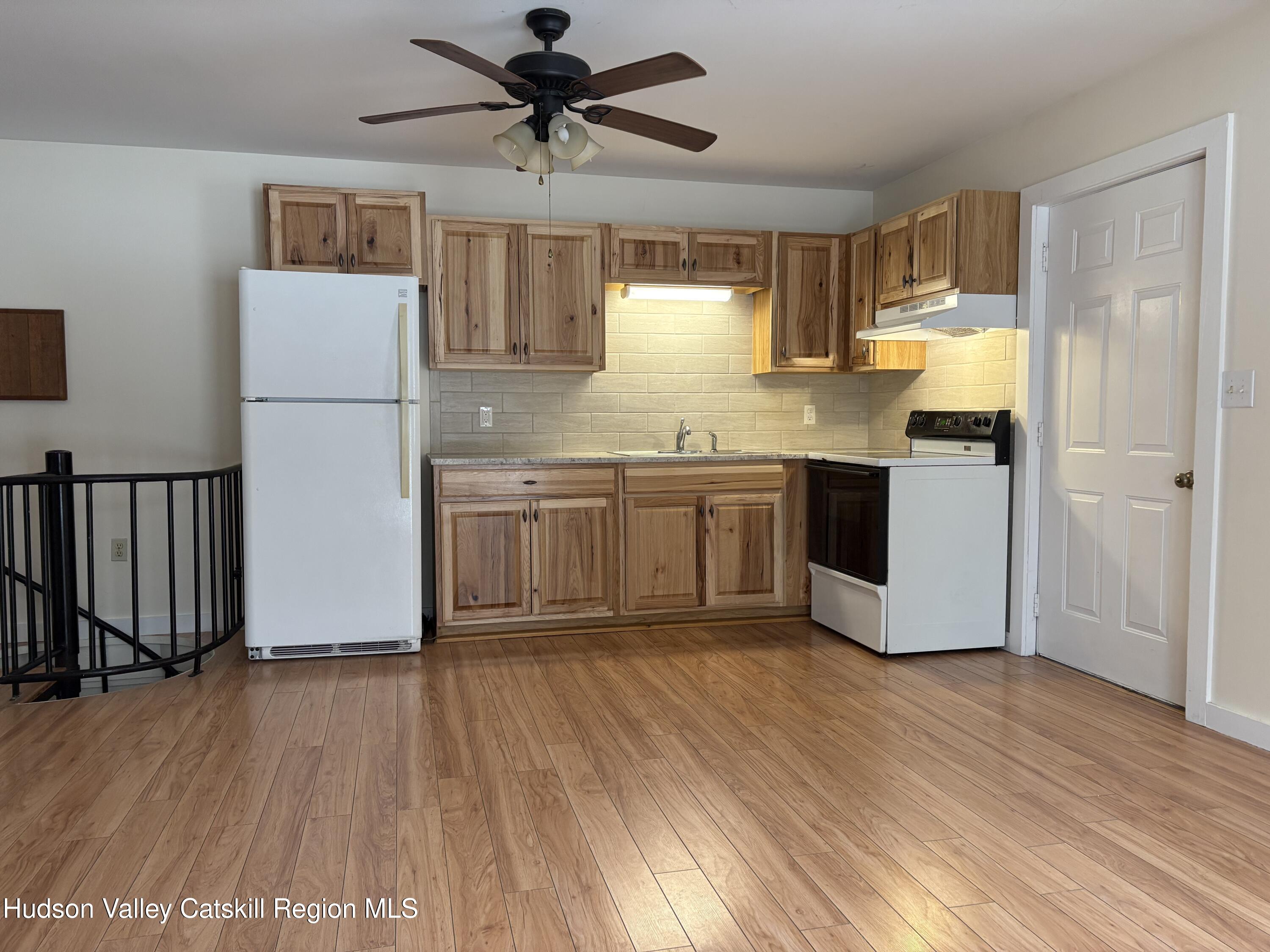 505 Highway 208, Unit 3 Gardiner, NY 12525 - Photo 2 of 11 a kitchen with kitchen island granite countertop wooden floors and white stainless steel appliances