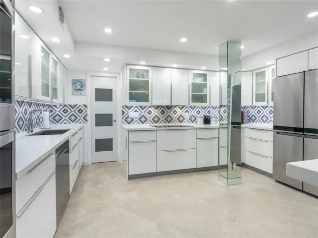 a kitchen with white cabinets and stainless steel appliances
