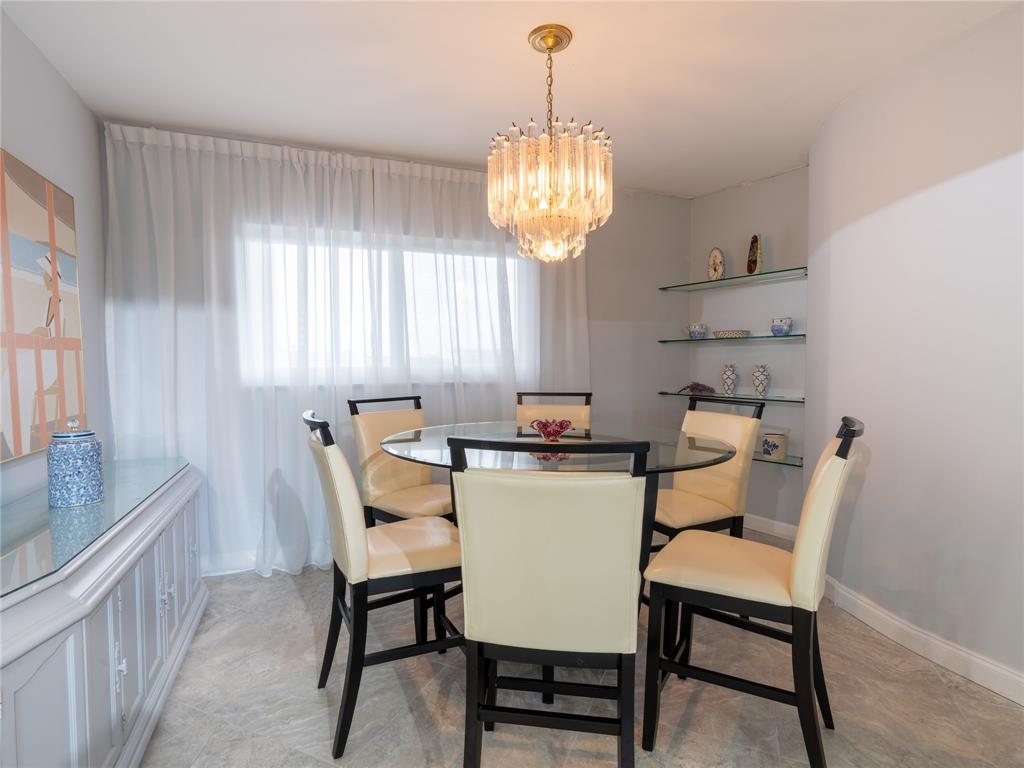 2850 North Palm Aire Drive, Unit 601 Pompano Beach, FL 33069 - Photo 17 of 41 a dining room with furniture a chandelier and window