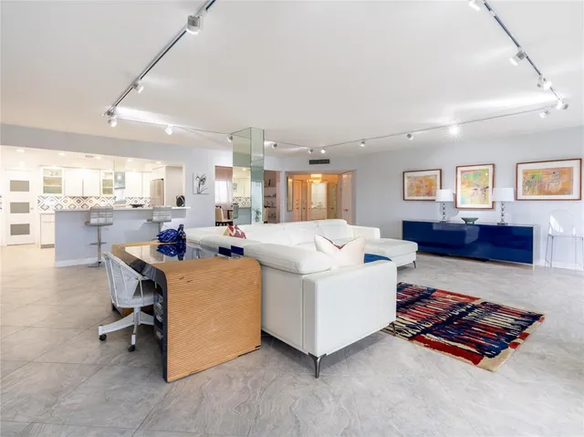 a living room with furniture and a dining table with kitchen view