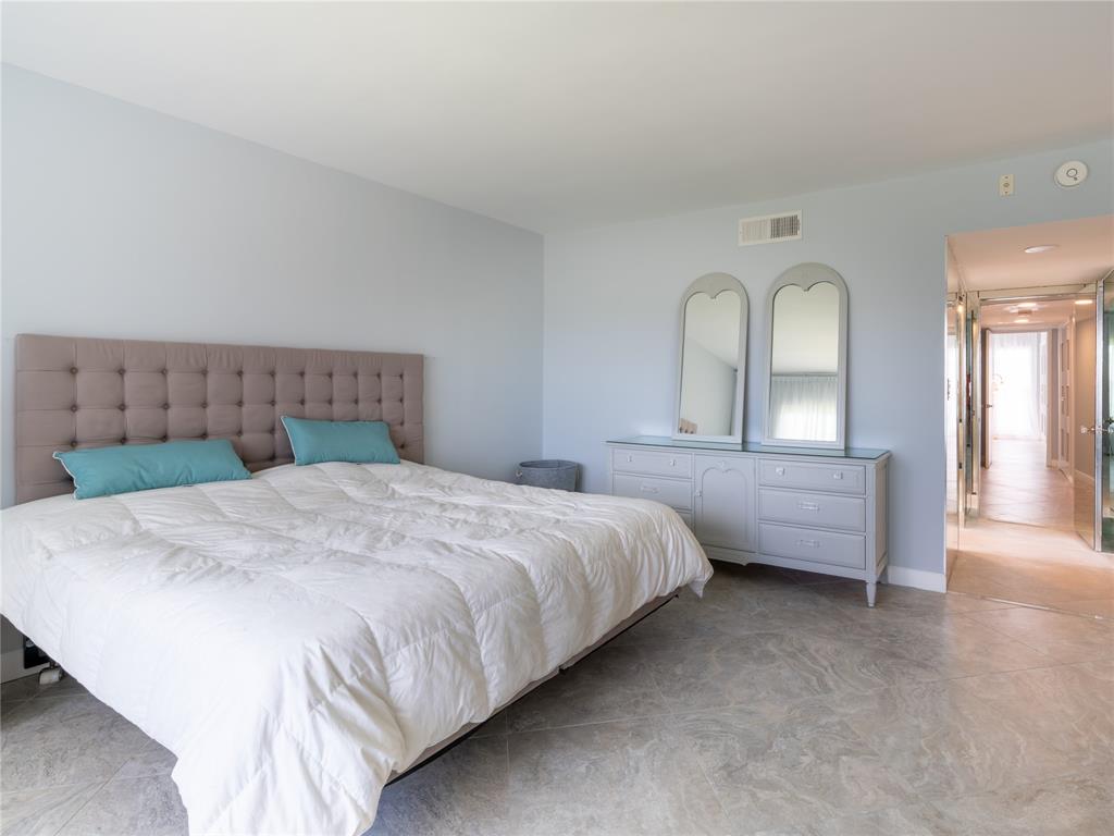 2850 North Palm Aire Drive, Unit 601 Pompano Beach, FL 33069 - Photo 21 of 41 a spacious bedroom with a bed and a dresser