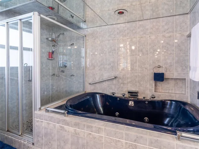 a bathroom with a tub a sink and glass door