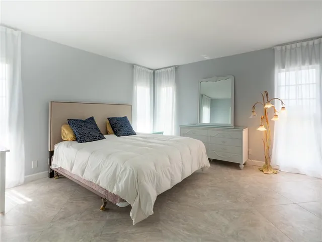 a spacious bedroom with a bed and a cabinets