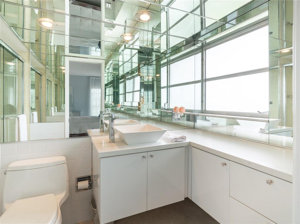 2850 North Palm Aire Drive, Unit 601 Pompano Beach, FL 33069 - Photo 28 of 41 a bathroom with a sink a toilet and a large mirror next to a large window