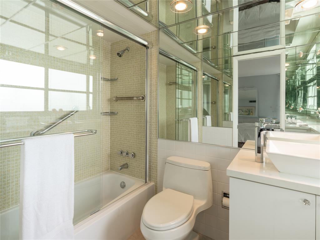 2850 North Palm Aire Drive, Unit 601 Pompano Beach, FL 33069 - Photo 29 of 41 a bathroom with a sink a toilet a mirror and shower