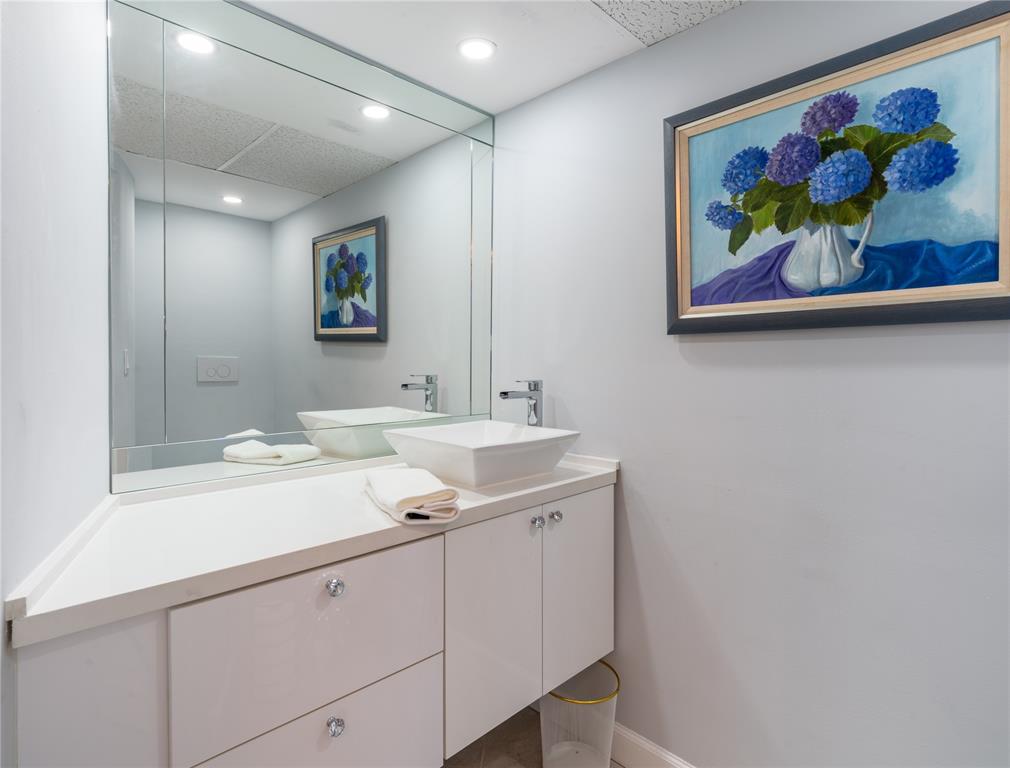2850 North Palm Aire Drive, Unit 601 Pompano Beach, FL 33069 - Photo 35 of 41 a bathroom with a sinks a large mirror and a painting on the wall