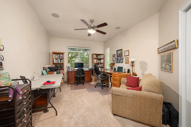 a living room with furniture and a ceiling fan