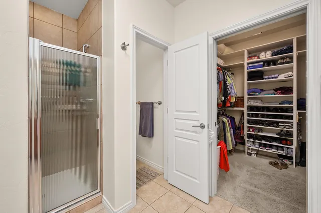 a view of walk in closet with clothes and shoes
