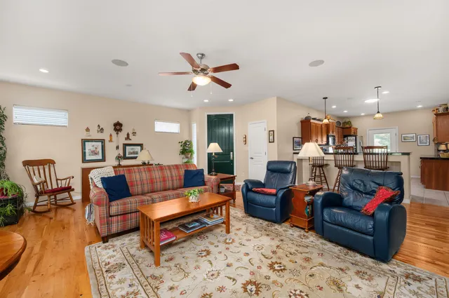 a living room with furniture kitchen view and a chandelier