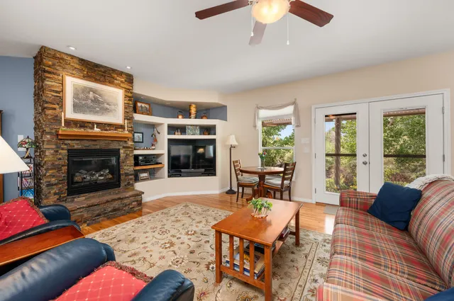 a living room with furniture a large window and a fireplace