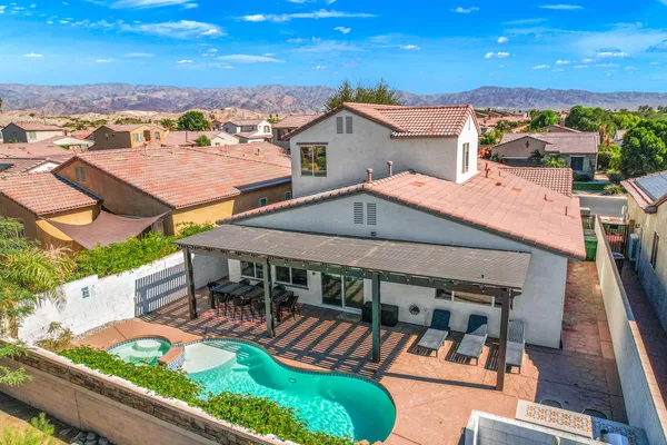 an aerial view of a house with swimming pool and furniture