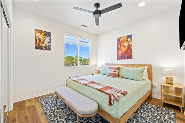 a bedroom with a bed and a painting on the wall